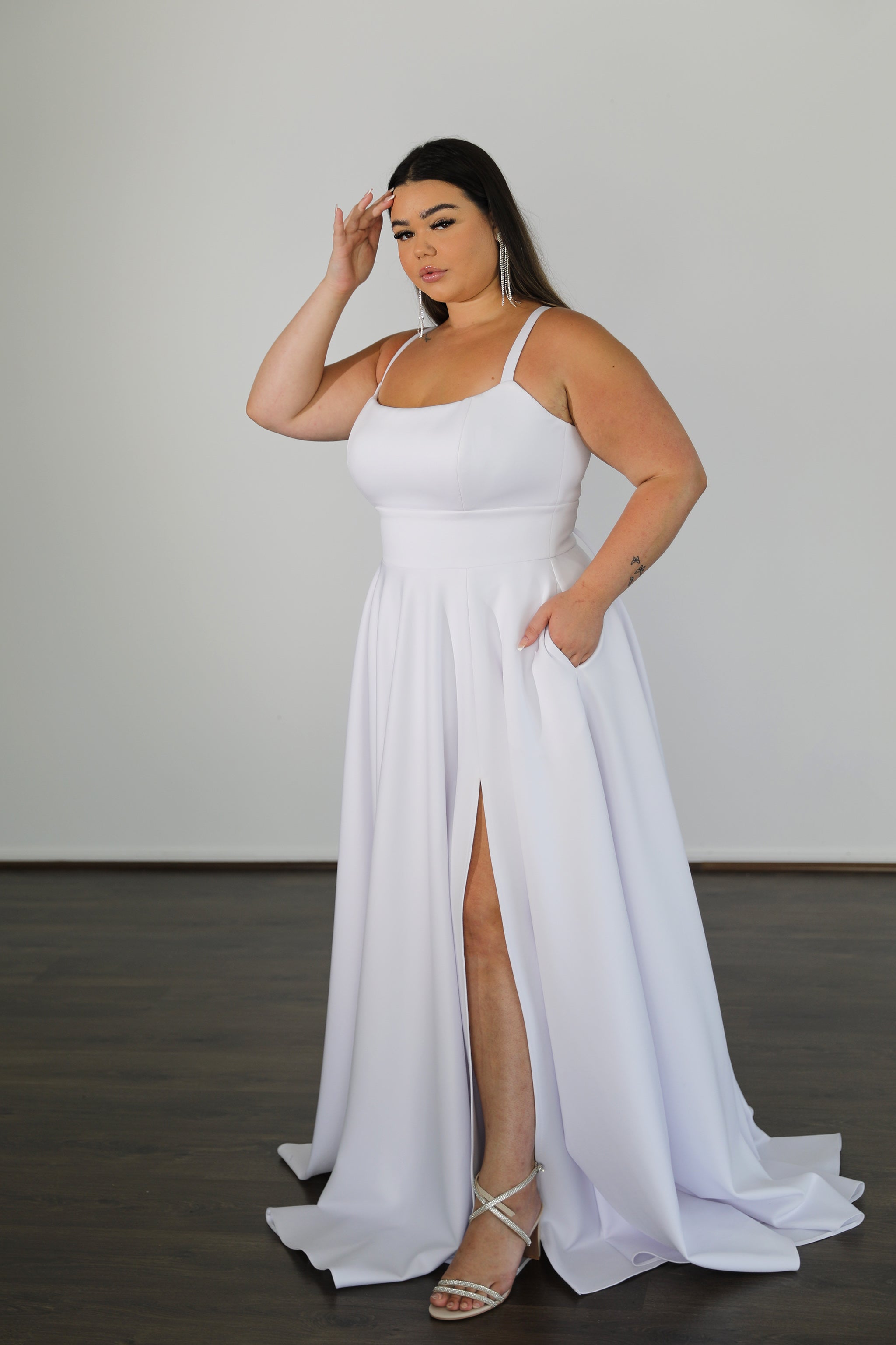 white formal gown with fitted top and flowing skirt featuring split